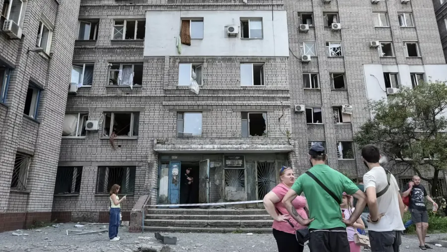 Residents stand near an apartment building that was damaged during a Russian missile strike